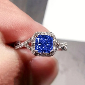 Vue macro d'une bague saphir bleu taille princesse avec anneau torsadé et diamants pavés
