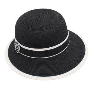 Detail of elegant black and white straw hat with camellia flower and striped trim