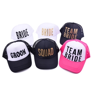 Overhead view of various mesh trucker hats with Bride, Groom and Squad gold lettering