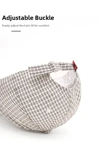 Detail of adjustable metal buckle on black and white checkered baseball cap