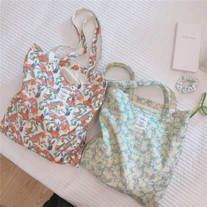 Detailansicht von zwei floralen Baumwolltaschen auf weißem gestepptem Stoffhintergrund