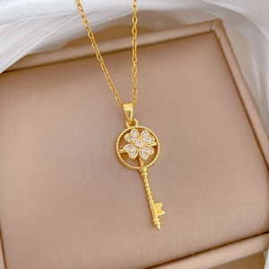 Elegant gold spinning key necklace with clover clover design and brilliant zircons