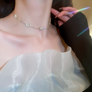 Detailed view of silver butterfly necklace with sparkling crystals on model's neckline