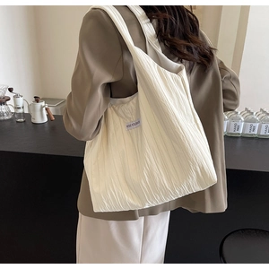 Detailansicht einer weißen gerafften Nylon-Schultertasche mit Kiss Yourself Etikett