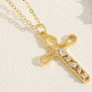 Detailed macro view of 18K gold-plated cross pendant with five sparkling zircon stones