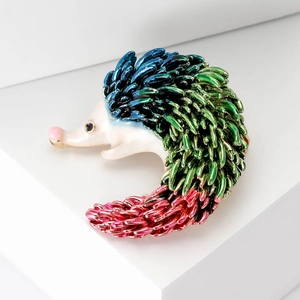 Macro detail of enamel hedgehog brooch with colorful blue green and pink gradient spikes