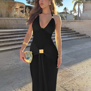 Détail d'une élégante robe dos nu noire avec boucle carrée en métal doré sur la taille froncée