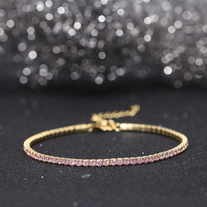 Macro shot of gold plated tennis bracelet featuring pink zircon stones in a row