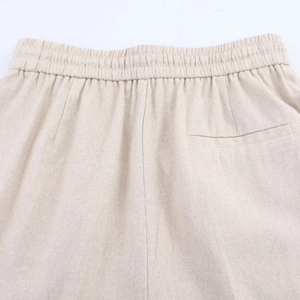 Detail of elastic waistband and back pocket on beige linen blend casual trousers