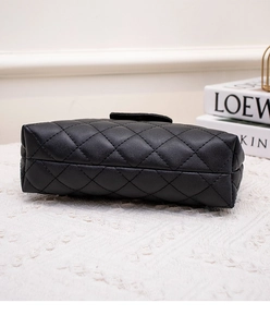 Detailed side view of black quilted faux leather handbag with diamond stitching