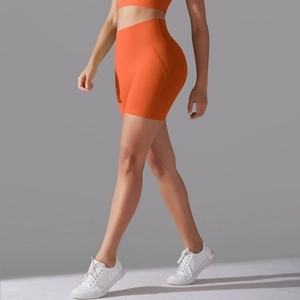 Macro view of bright orange high-waisted fitness shorts with ergonomic contour stitching