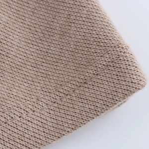 Close-up of the soft knit fabric texture and woven pattern on the light beige sweater set