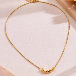 Retro gold titanium necklace featuring five textured beads on a delicate box chain