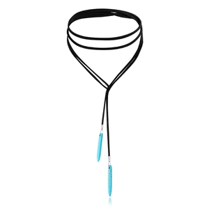 Detail of bohemian black choker with long turquoise stone pendants on plain background