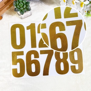 Detail of 4-inch gold waterproof number stickers with metallic texture and water droplets