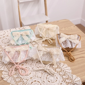 Close-up of five colorful straw mini bags featuring lace frills and large bow details