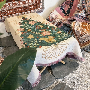 Detail of Christmas tree jacquard blanket with fringes and festive squirrel pattern