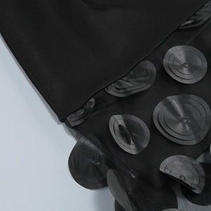 Detail of 3D round appliqués and sheer mesh layers on the black tube party dress