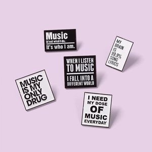 Minimalist black and white enamel music badges on a light purple background