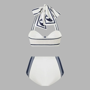 Detailed flat lay of white bikini set with navy stripes and whale bow halter top