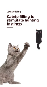 Action shot of a cat jumping for the black plush catnip toy with crinkle paper filling