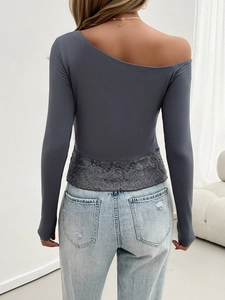 Detail of grey Y2K knit top featuring asymmetric off-shoulder and lace hem on the back