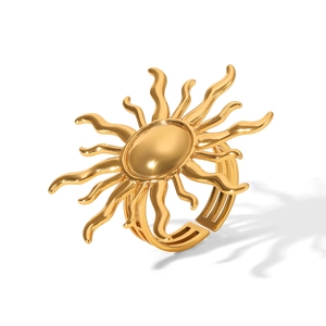 Macro shot of a golden sunburst adjustable ring with radiant lines on white background