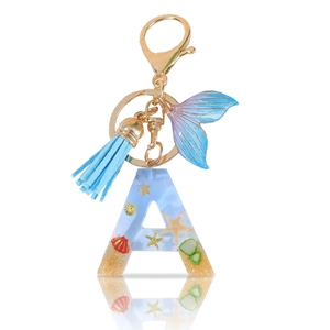 Letter A resin keychain with ocean shells, blue mermaid tail and tassel on white background