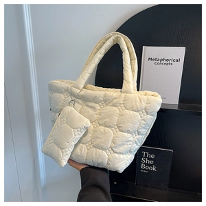 Detail of cream quilted tote bag with matching mini coin purse and puffy round stitching