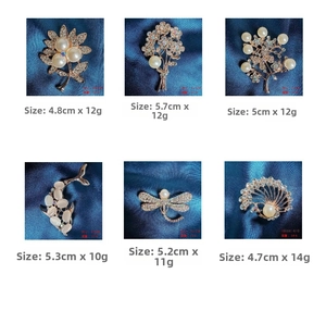 Detailed grid of assorted gold-tone brooches featuring pearls and crystals on blue silk