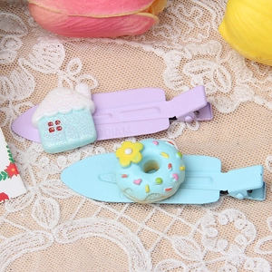 Detail of colorful purple house and blue donut resin hair clips on lace background