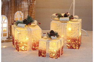 Macro view of woven Christmas gift boxes with pine cones and warm LED lights