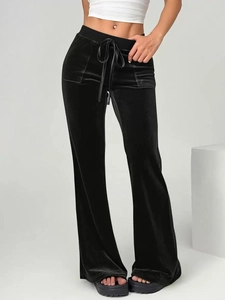 Detail of high-waist drawstring on black velvet flared pants showing premium texture