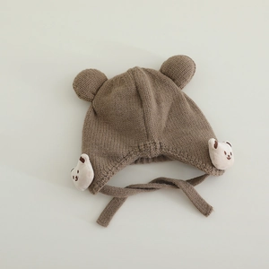 Detailansicht der braunen Baby-Strickmütze mit Bärenohren, Plüschbären und Bändern