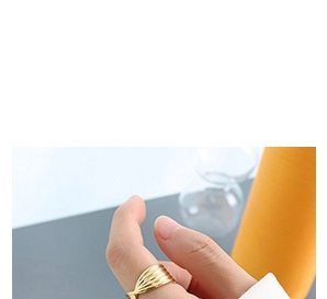 Detail shot of wide gold plated titanium steel ring with twisted wave pattern on hand