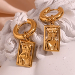 Macro shot of 18K gold plated earrings featuring artistic female torso relief pendants