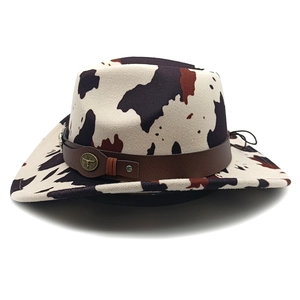 Detail of vintage cow print cowboy hat featuring a leather band and bull head emblem