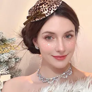 Elegant leopard print top hat with brown velvet bow shown on model in festive setting