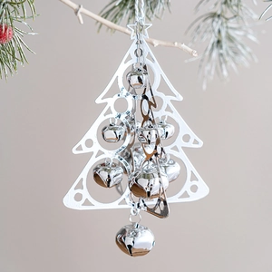 Silver metal Christmas tree ornament with bells hanging on a festive pine branch