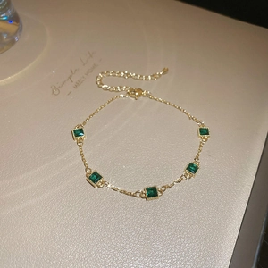 Détail du bracelet plaqué or avec pierres d'émeraude carrées et cristaux brillants