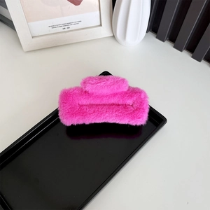 Pink plush rectangular hair claw clip on a minimalist display tray for winter styling
