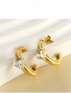Detail of 18k gold plated C-shape earrings with heart-cut cubic zirconia settings