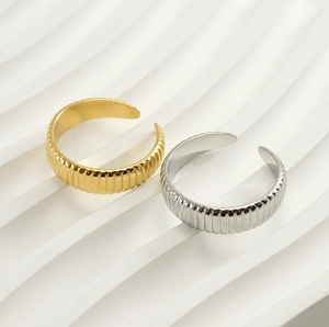 Detailed view of gold and silver adjustable open rings with vertical ribbed texture