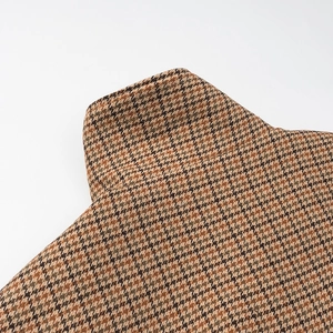 Detailed macro view of the brown houndstooth wool fabric texture on the stylish jacket