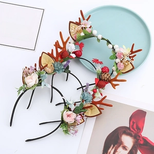 Detail of Christmas reindeer antler headband with silk flowers, berries and pine cones