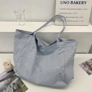 Detail of spacious canvas tote bag featuring a decorative silver star sequin pattern