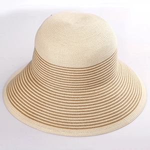 Close-up of the detailed beige and light brown woven stripes on a wide brim straw sun hat