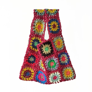 Close-up of handmade crochet tote bag featuring multi-color floral patchwork and red base