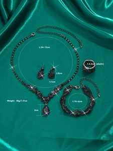Detailed view of black rhinestone bridal jewelry set with necklace and earrings on silk