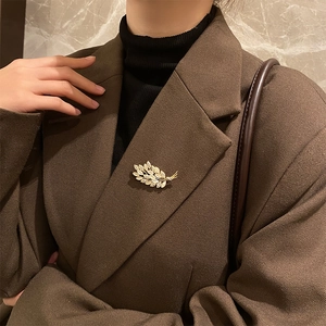 Elegant opal wheat ear brooch in gold finish with diamonds on a suit lapel